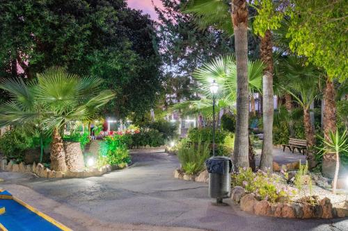a park at night with palm trees and a trash can at APARTAMENTOS PALASIET in Benidorm