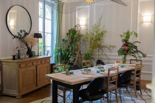 a dining room with a table and chairs and a mirror at Chez Agnès in Pont-lʼÉvêque