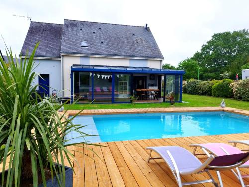 una casa con piscina frente a una casa en Chambre d'hôtes salle d'eau et WC privés, véranda,extérieurs et piscine chauffée, en Guérande