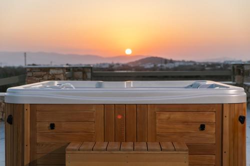 a bath tub with the sunset in the background at Naxian green life in Agia Anna Naxos