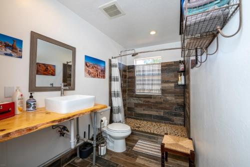 a bathroom with a shower and a toilet and a sink at BaseCamp 37° in Kanab