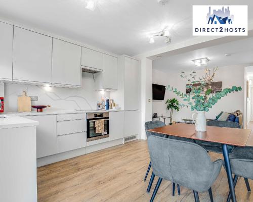 a kitchen and dining room with a table and chairs at Stylish Two Bedroom Apartments by Direct2hosts Short Lets West London Oasis With Workspace & Long Stays in London