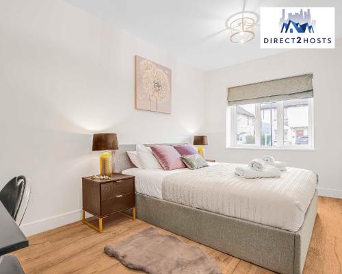 a bedroom with a bed and a nightstand and a window at Stylish Two Bedroom Apartments by Direct2hosts Short Lets West London Oasis With Workspace & Long Stays in London