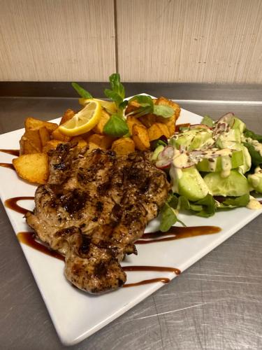 a plate of food with meat and a salad at Hotel Oppium Restaurant & Garden in Ruse