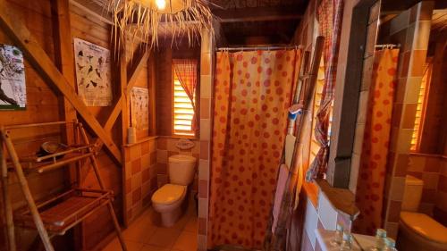 a small bathroom with a toilet and a sink at Bungalows du Soleil - Piscine Jardin Fleuri in Le Gosier