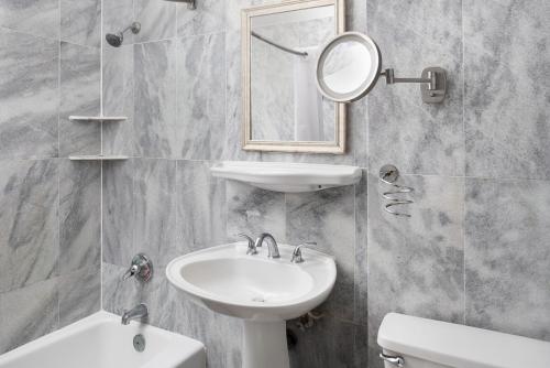 uma casa de banho com um lavatório, um espelho e um WC. em Sherry Frontenac Oceanfront em Miami Beach
