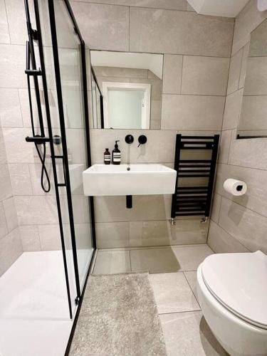 uma casa de banho com um lavatório e um WC em Londwell, Luxe and Leaves, Chelsea Flat with Private Garden em Londres