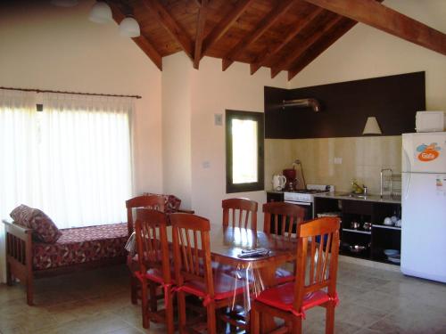 une cuisine et une salle à manger avec une table et des chaises dans l'établissement Miralagos Apart & Cabañas, à Villa Pehuenia