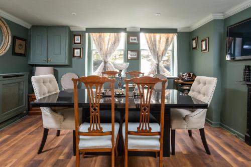 a dining room with a black table and chairs at Abbey Mews in the heart of Bath in Bath