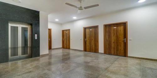 Habitación vacía con puertas de madera y techo en Hotel Cymbal -Sector 31 Gurgaon, en Gurgaon
