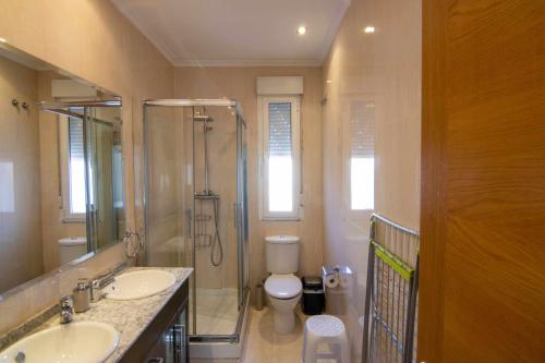 y baño con ducha, 2 lavabos y aseo. en Apartamento paris en León