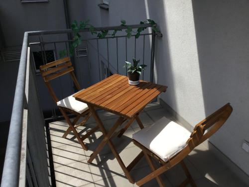 d'une table en bois et de deux chaises sur un balcon. dans l'établissement Earl Grey Apartment Wien, à Vienne
