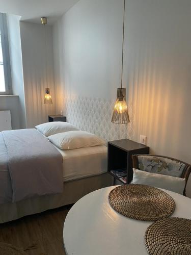 sypialnia z 2 łóżkami, stołem i 2 krzesłami w obiekcie Hysope : Studio aux couleurs toutes douces ! w mieście Bagnères-de-Bigorre