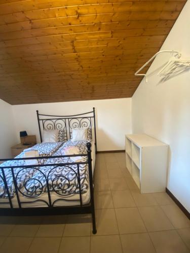 um quarto com uma cama e um tecto de madeira em BellaVista Cureglia em Cureglia