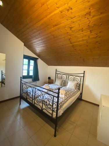 Cama en habitación con techo de madera en BellaVista Cureglia, en Cureglia