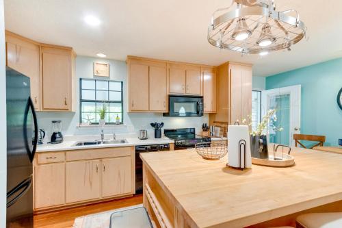 a kitchen with wooden cabinets and a refrigerator at Bright Navarre Vacation Rental, 2 Mi to Beach! in Navarre