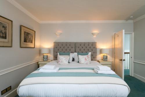 a bedroom with a large white bed with pillows at Abbey Mews in Bath