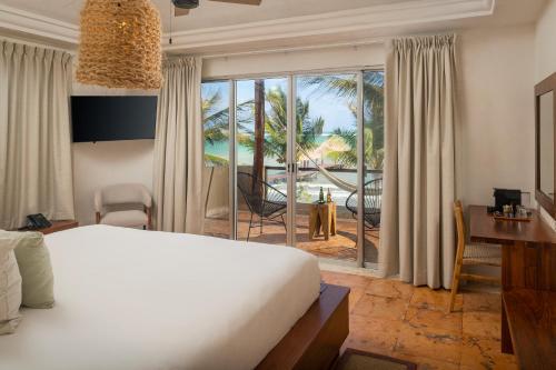 Un dormitorio con una cama y vista al mar. en Mereva Tulum, en Tulum
