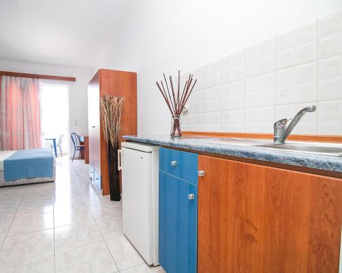 uma cozinha com um lavatório e uma bancada em Ano Kampos Hotel em Faliraki