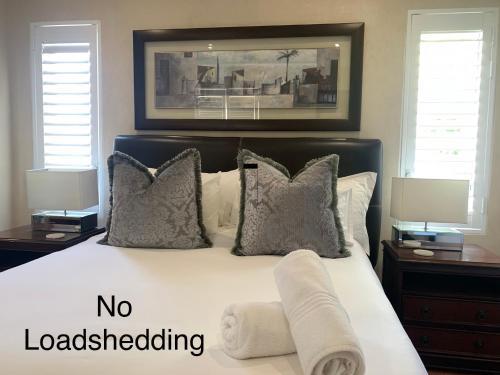 a bedroom with a bed with no load shedding towels on it at Swanepoel Guesthouse in Jeffreys Bay