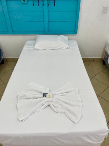 a white bed with a shirt and tie on it at Hostal Inn 2 in Flores
