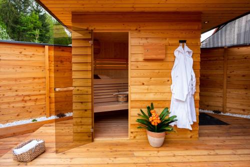 a wooden sauna with a white dress hanging on the wall at House "HISCA" With Private Terrace, BBQ, Fireplace, Sauna, Hot Tub in Mozirje