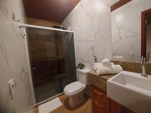 uma casa de banho com um chuveiro, um WC e um lavatório. em Casa Duplex em Pedra Azul em Domingos Martins