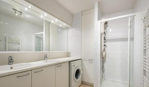 a white bathroom with a washing machine and a sink at Vue sur mer, dunes et golf in Wimereux