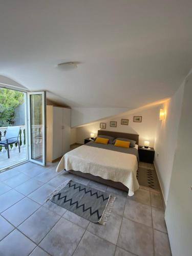 a bedroom with a large bed and a balcony at Apartments Lokunja in Pag