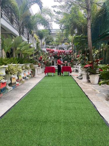 a person standing on a green carpet in a garden at The VeeHive Guesthouse in Moalboal