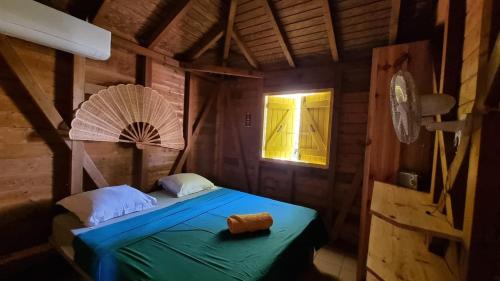 a bedroom with a bed in a wooden room at Bungalows du Soleil - Piscine Jardin Fleuri in Le Gosier