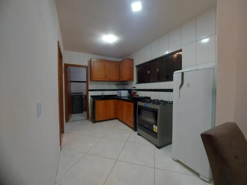 cocina con armarios de madera y nevera en Casa Duplex em Pedra Azul en Domingos Martins