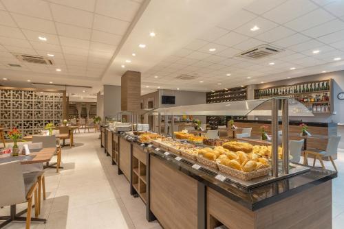 Hotel Laghetto Rio Grande في ريو غراندي: مخبز مع خزانة عرض مليئة بالكثير من الطعام