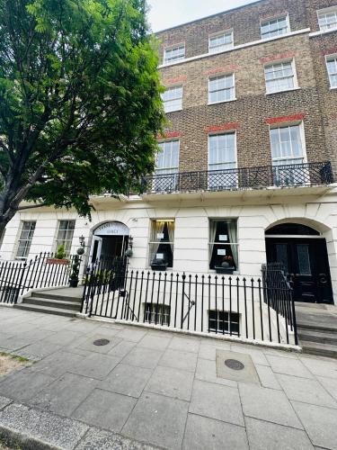 a building with a fence in front of it at Thanet Hotel Annex in London
