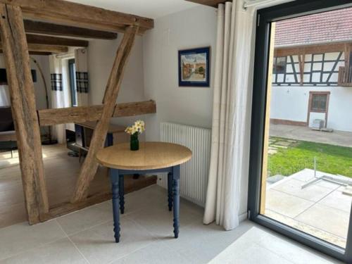 une petite table dans une pièce avec une fenêtre dans l'établissement Corps de ferme alsacien, à Grassendorf