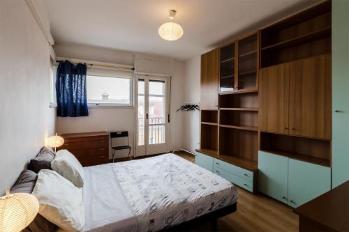 1 dormitorio con cama, escritorio y ventana en Appartamento Slataper - ampio e con vista en Trieste