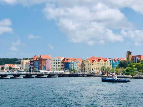 a boat in a body of water with buildings and a bridge at VillaDelSol-Ocean Front Resort-Pool-up to 8 Guests-Walk to the Beach in Willibrordus