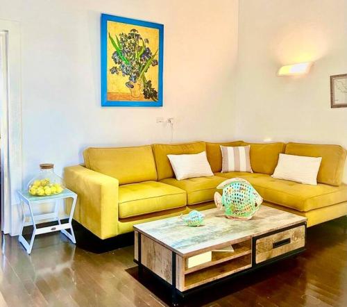 a living room with a yellow couch and a table at VillaDelSol-Ocean Front Resort-Pool-up to 8 Guests-Walk to the Beach in Willibrordus