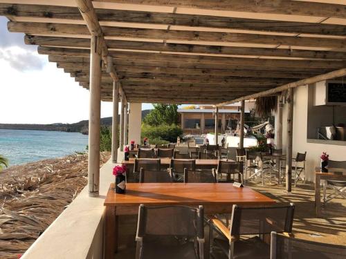 a restaurant with a table and chairs and the water at VillaDelSol-Ocean Front Resort-Pool-up to 8 Guests-Walk to the Beach in Willibrordus