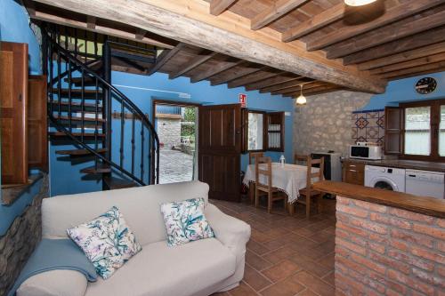 uma sala de estar com um sofá e uma cozinha em Madre Rosa II, bonita casa a 12 km de la playa em Llanes