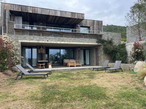 Maison en pierre avec 2 chaises et une table dans l'établissement A1 Magnifique appt 6 personnes Lofts de Ste Lucie, à Zonza