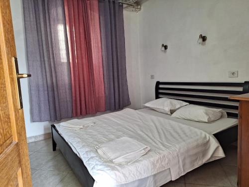 a bedroom with a bed with white sheets and a window at Forteca home in Perast
