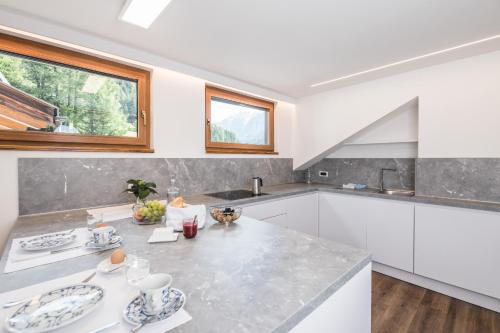 a kitchen with white cabinets and a counter top at Apartments Chalet Zirm in Santa Cristina in Val Gardena