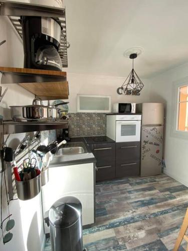 une cuisine avec un évier et une cuisinière dans l'établissement Charmant studio climatisé proche de la mer, à Sanary-sur-Mer