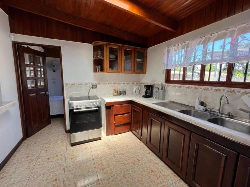 a kitchen with a sink and a stove top oven at Amplia Casa en Paquera in Paquera