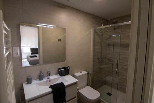 a bathroom with a toilet and a sink and a shower at Suite estocolmo in León