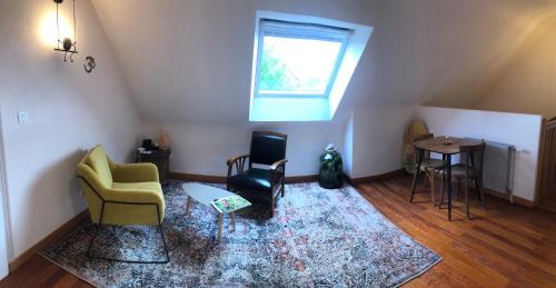 a living room with two chairs and a window at Chambre chez l'habitant "Les Roses de Séné" in Séné