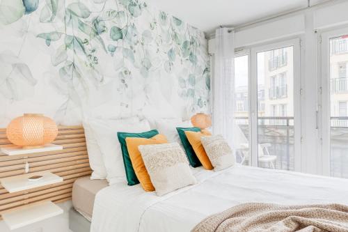 - une chambre avec un lit et des oreillers colorés dans l'établissement DisneyLand Paris Station 2min, à Chessy