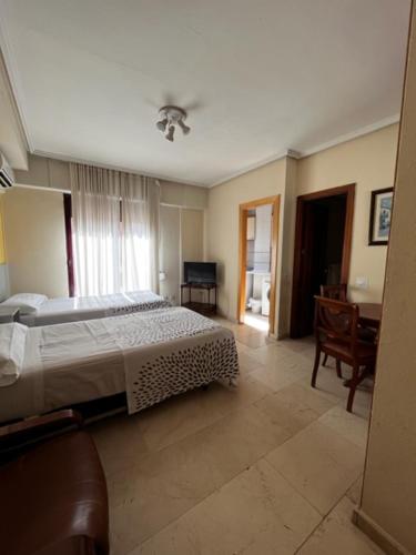 1 dormitorio con cama y escritorio. en Apartamentos Olano C.B., en Madrid