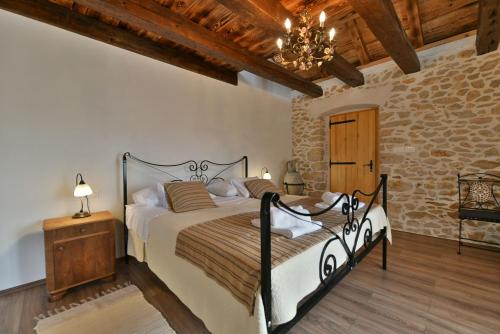 a bedroom with a bed and a stone wall at Villa Gland in Nin
